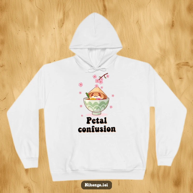 Funny hoodie graphic of a ramen bowl in a conical hat trying to catch falling cherry blossoms, cozy and humorous.